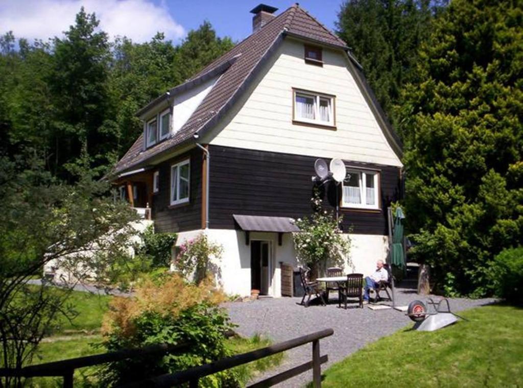 a house with a person sitting in front of it at Vakantiehuis ibu in Altenau