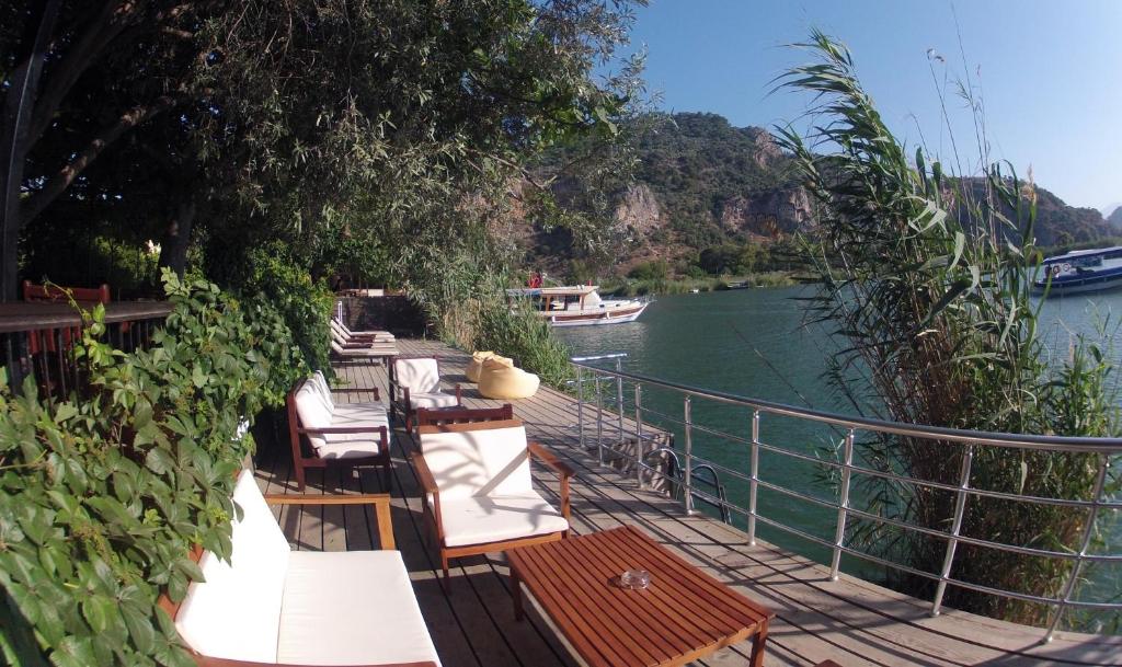 a group of tables and chairs on a dock next to a river at Lindos Pension in Dalyan