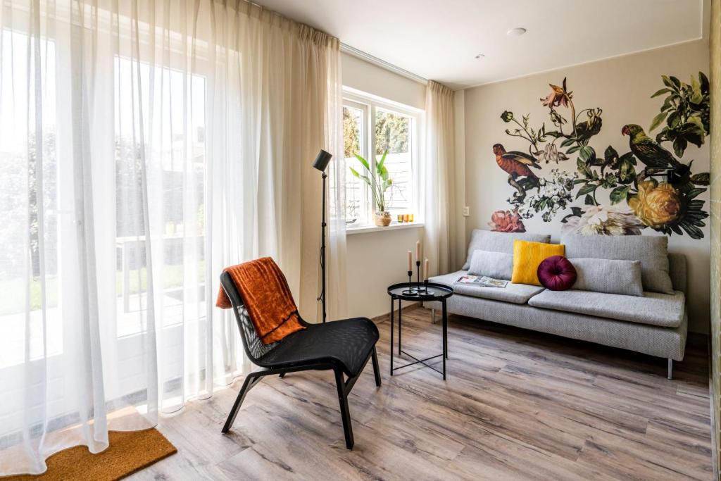 a living room with a couch and a chair at Charley's Home 2 personen in Westkapelle