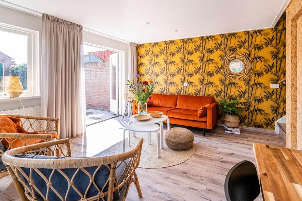 a living room with an orange couch and a table at Charley's Home 4 personen in Westkapelle