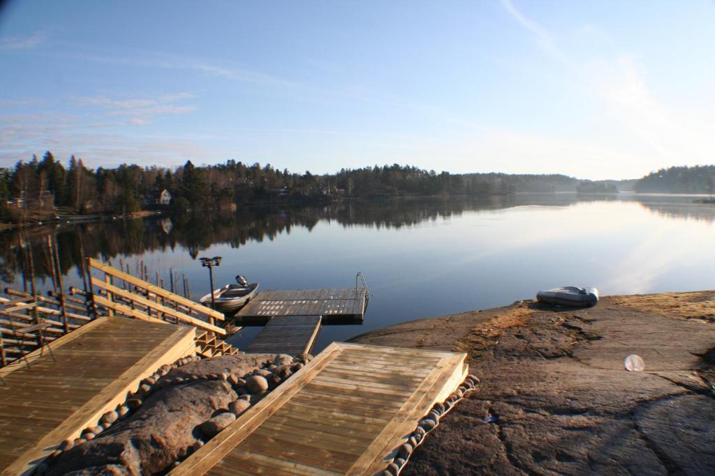 Vendelsö的住宿－Sjöställe Gudö，湖岸上设有两艘船的码头