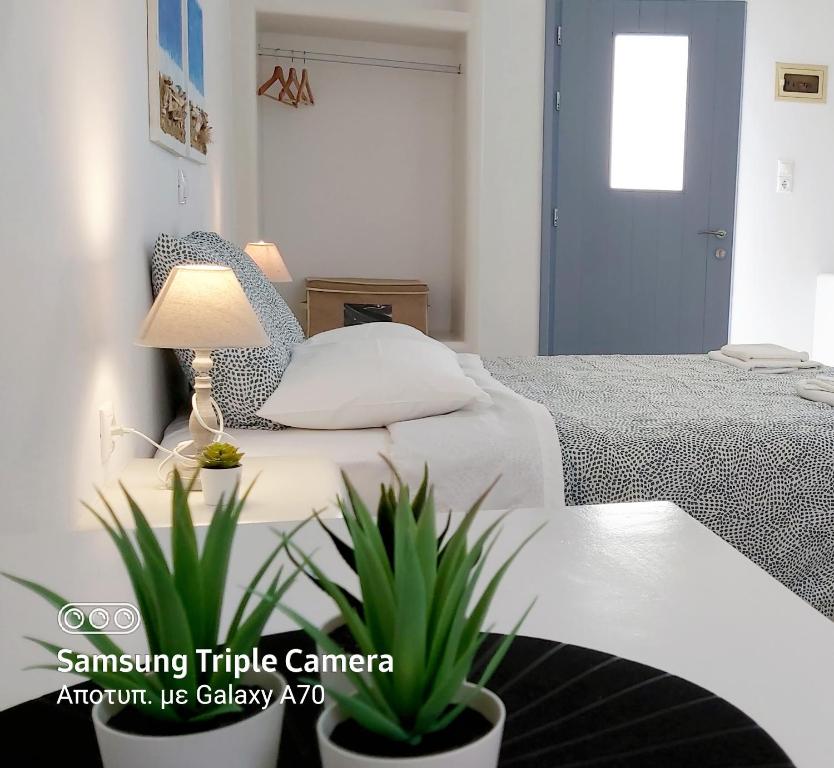 a bedroom with a bed and a table with a lamp at Sunny Studios Naxos in Aliko Beach