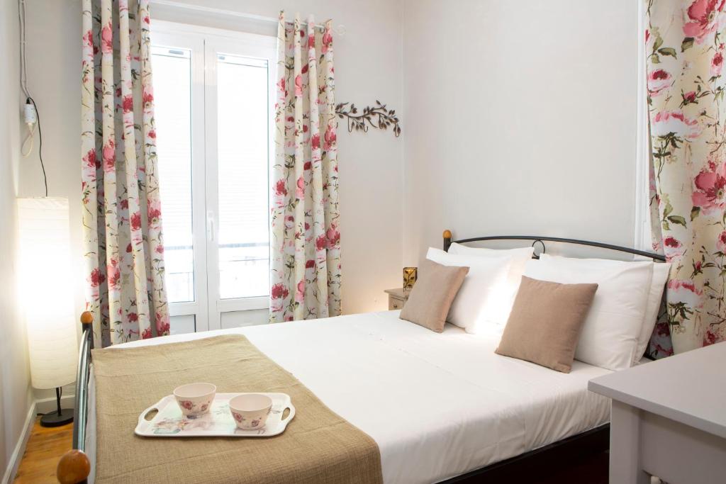 a bedroom with a bed with two cups and a tray at Akratos wine house in Nydri