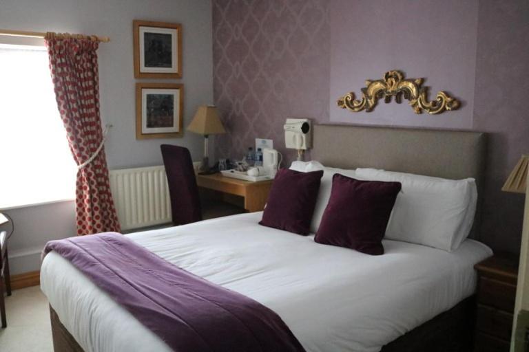 a hotel room with a large bed and a desk at New Park Hotel Athenry in Athenry