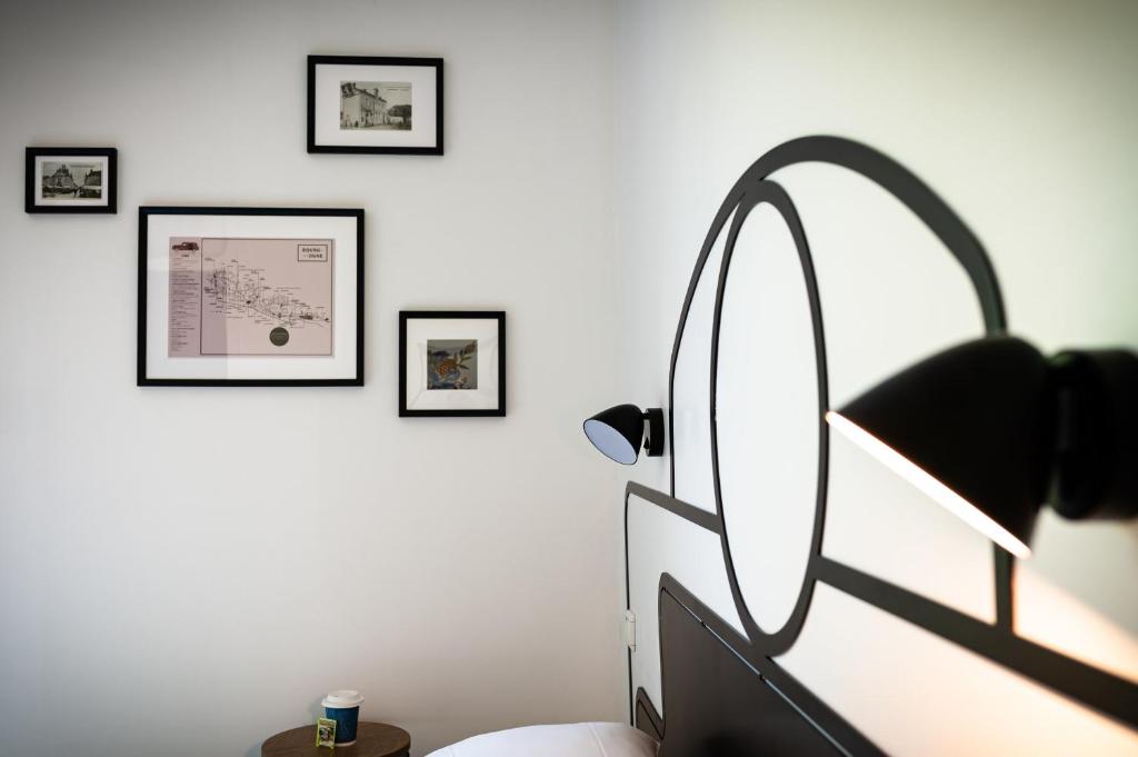 1 dormitorio con espejo y cuadros enmarcados en la pared en Kyriad Nuits-Saint-Georges en Nuits-Saint-Georges