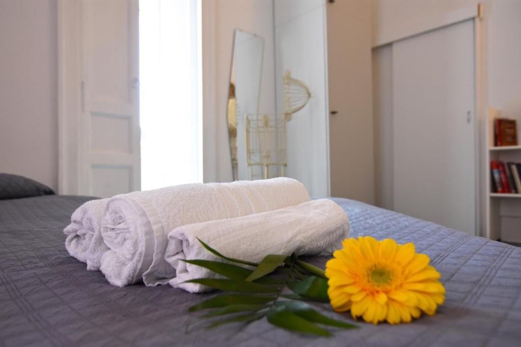 łóżko z dwoma ręcznikami i żółtym kwiatem w obiekcie Nanà Bed and Breakfast w mieście Napoli
