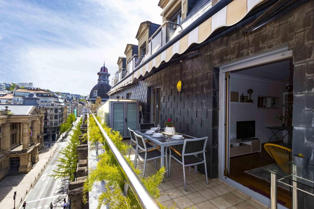 a balcony with a table and a view of a city at Aire de la Concha - The Rentals Collection in San Sebastián