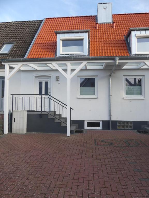 a white house with an orange roof and a brick driveway at Samlandhaus in Timmendorfer Strand