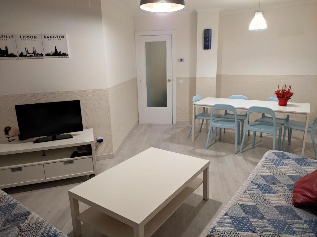 ein Wohnzimmer mit 2 Tischen und einem TV in der Unterkunft Apartseu in La Seu d'Urgell