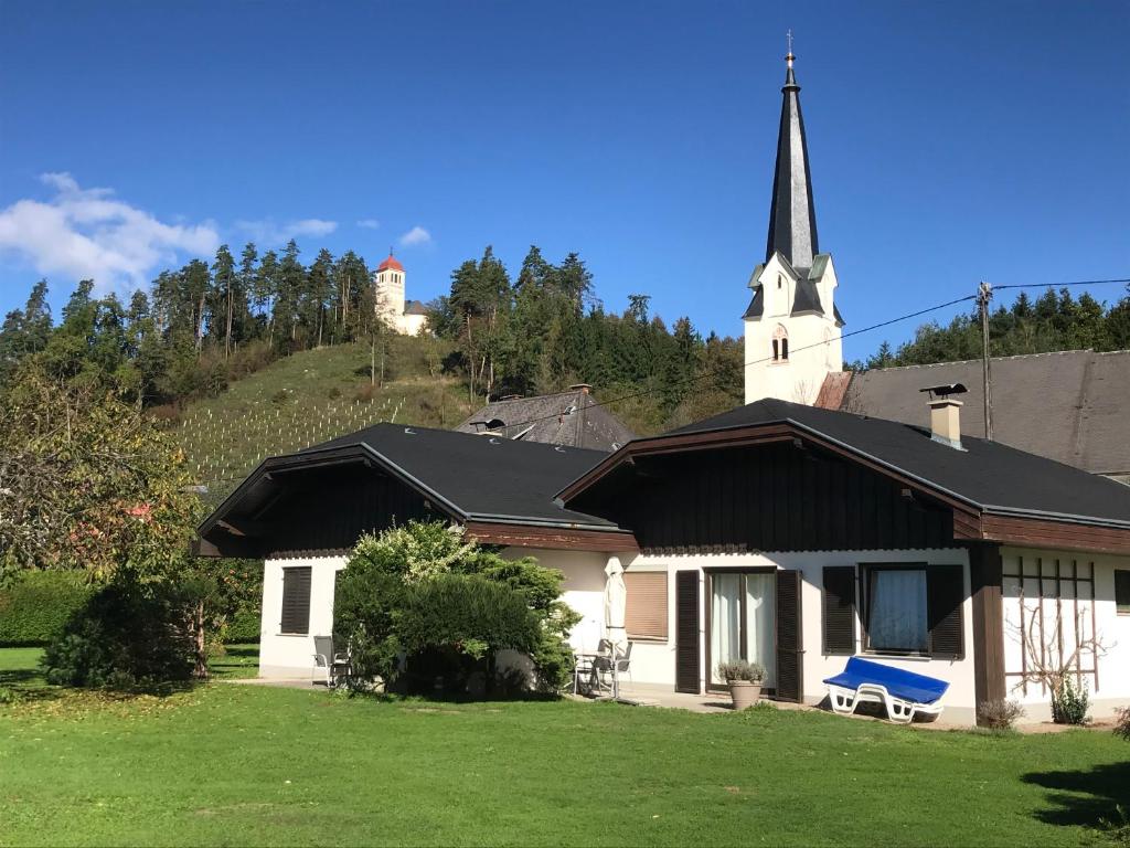 una iglesia con un banco azul delante de ella en V Gemütliches Gartenhaus en Sankt Michael ob Bleiburg