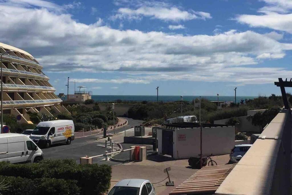 - une vue sur un parking avec des voitures et un bâtiment dans l'établissement Village naturiste Studio Port Nature 3, Cap d'Agde, au Cap d'Agde