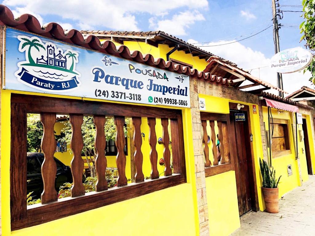 a store with a sign on the side of a building at Pousada Parque Imperial no centro de Paraty in Paraty