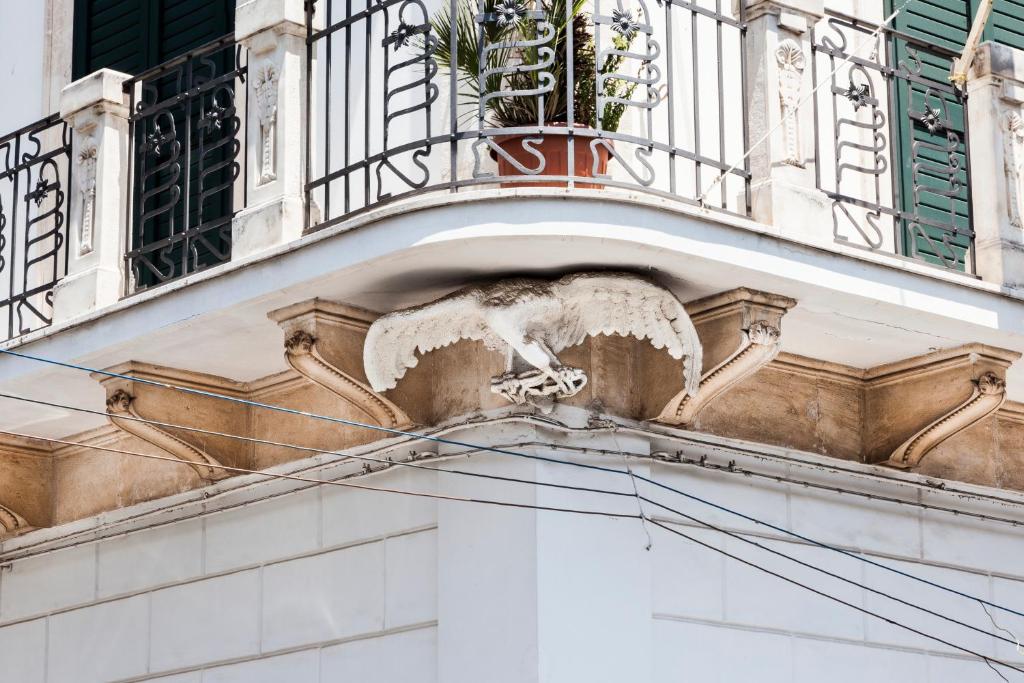 een gebouw met een balkon met een plant erop bij B&B Aquila in Alberobello