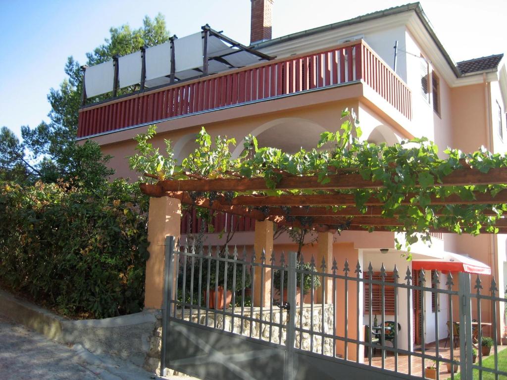 a house with a balcony with plants on it at Apartments Morski Vuk in Tivat