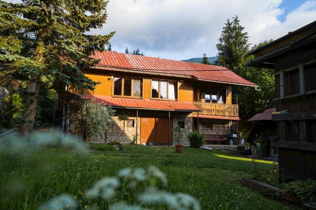 ein Haus mit einem roten Dach und einem Hof in der Unterkunft Chalupa v Štefanovej in Žilina
