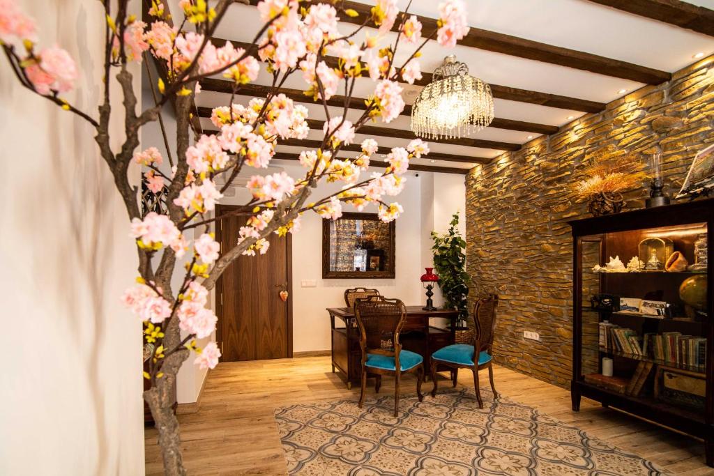 pokój ze stołem i drzewem z różowymi kwiatami w obiekcie Maremar Suites w mieście Benidorm