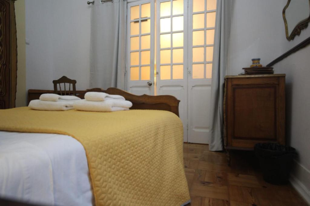 a bedroom with a bed with towels on it at Antique, Amazing double room in Marques de Pombal with shared Bathroom in Lisbon