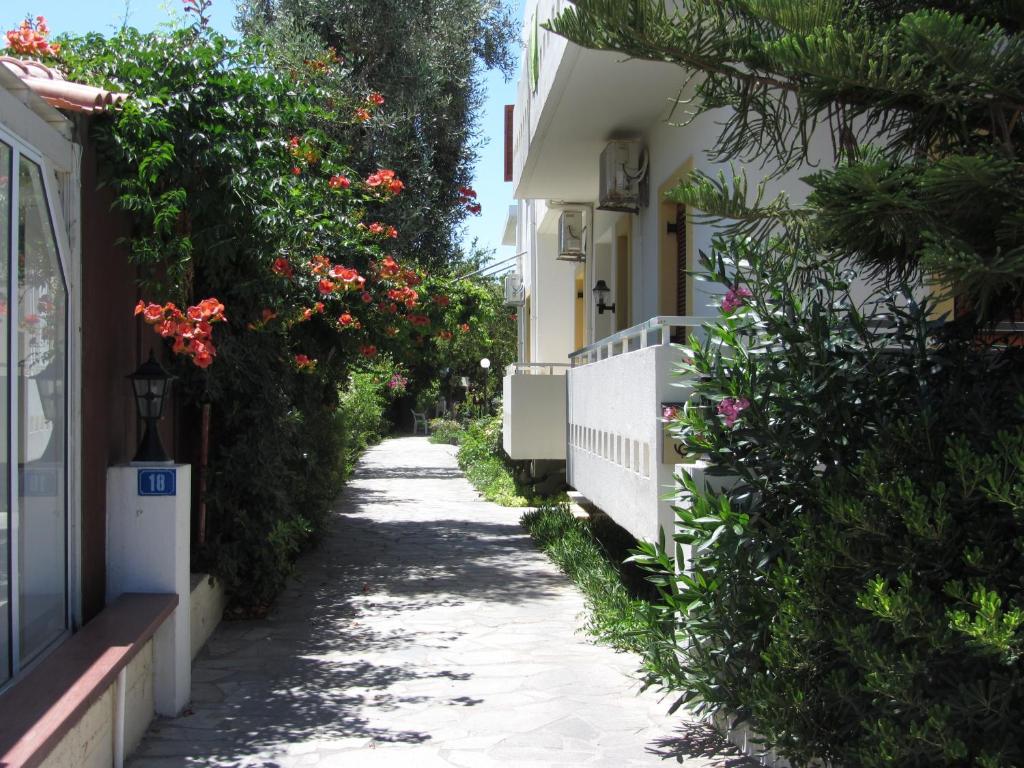 
a white house with trees and bushes at Michael Apartments in Rethymno
