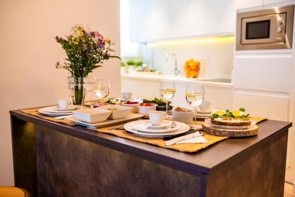 una mesa con platos de comida y copas de vino en Tourist House Santa Maria de Gracia, en Carmona