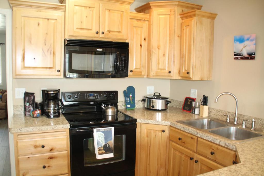 a kitchen with a black stove and a sink at 3 queen beds, 1 twin bed, 2 rooms, 1 and a half bath, self check-in, flexcation equipped in Idaho Falls