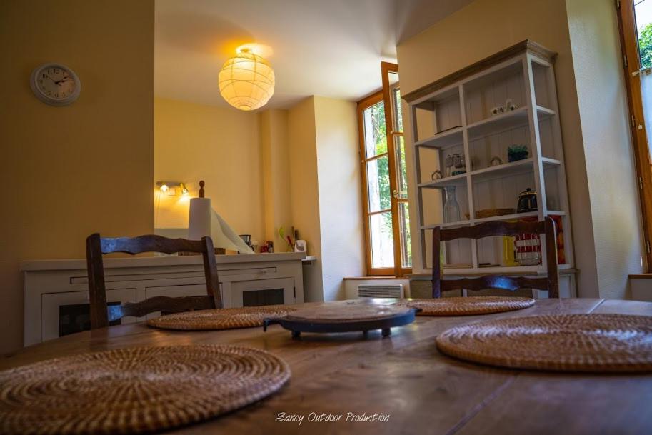 una habitación con una mesa con cuatro esteras. en les tilleuls, en Besse-et-Saint-Anastaise