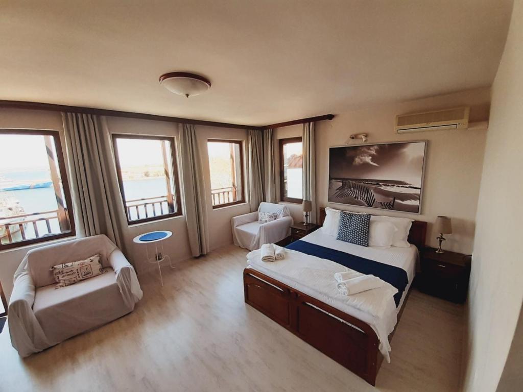 ソゾポルにあるGuest House Fotini 2のベッド1台、椅子、窓が備わる客室です。
