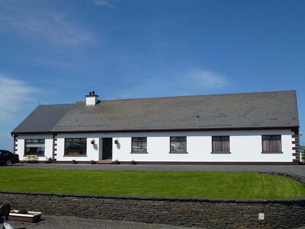 a white house with a black roof at Cois Farraige in Lahinch