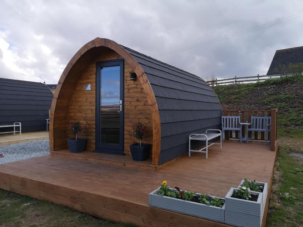 ein großes Kuppelhaus aus Holz mit einer Terrasse in der Unterkunft Lochview Pods in Harlosh