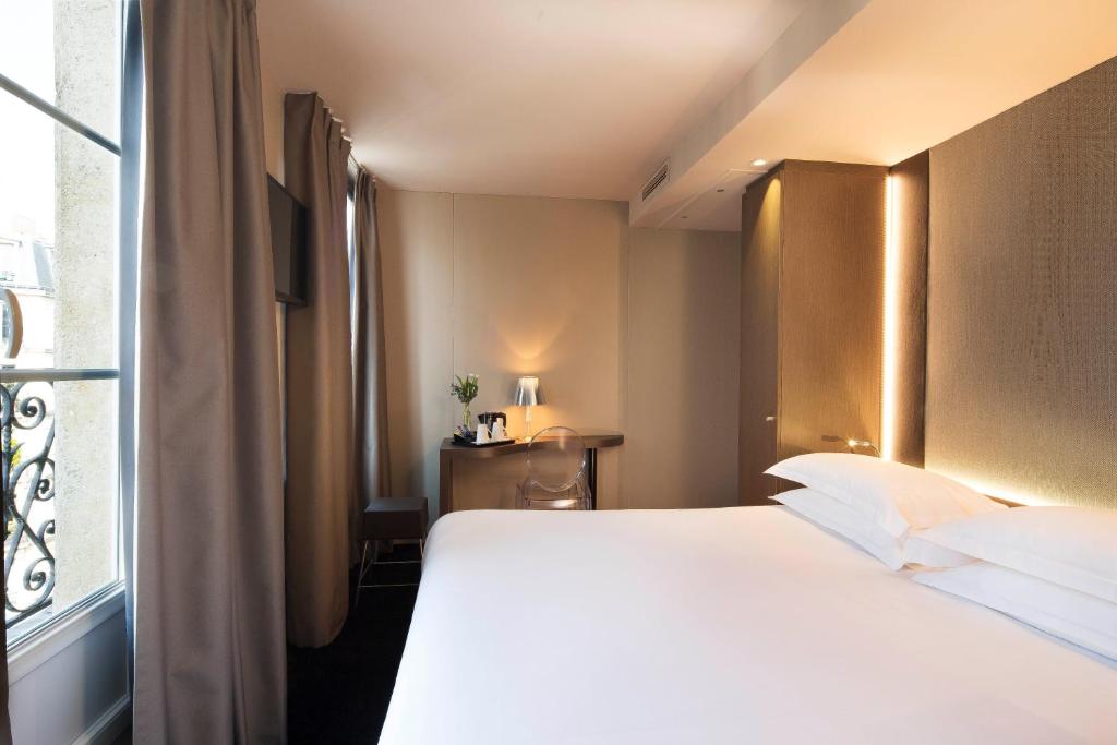 a bedroom with a large bed and a window at Best Western Quartier Latin Pantheon in Paris