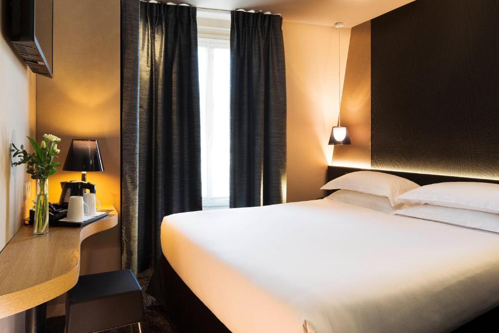 a hotel room with a bed and a window at Best Western Quartier Latin Pantheon in Paris