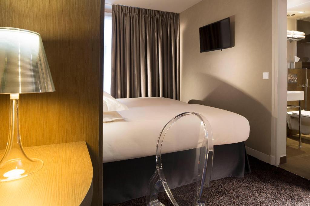 a hotel room with a bed and a lamp at Best Western Quartier Latin Pantheon in Paris