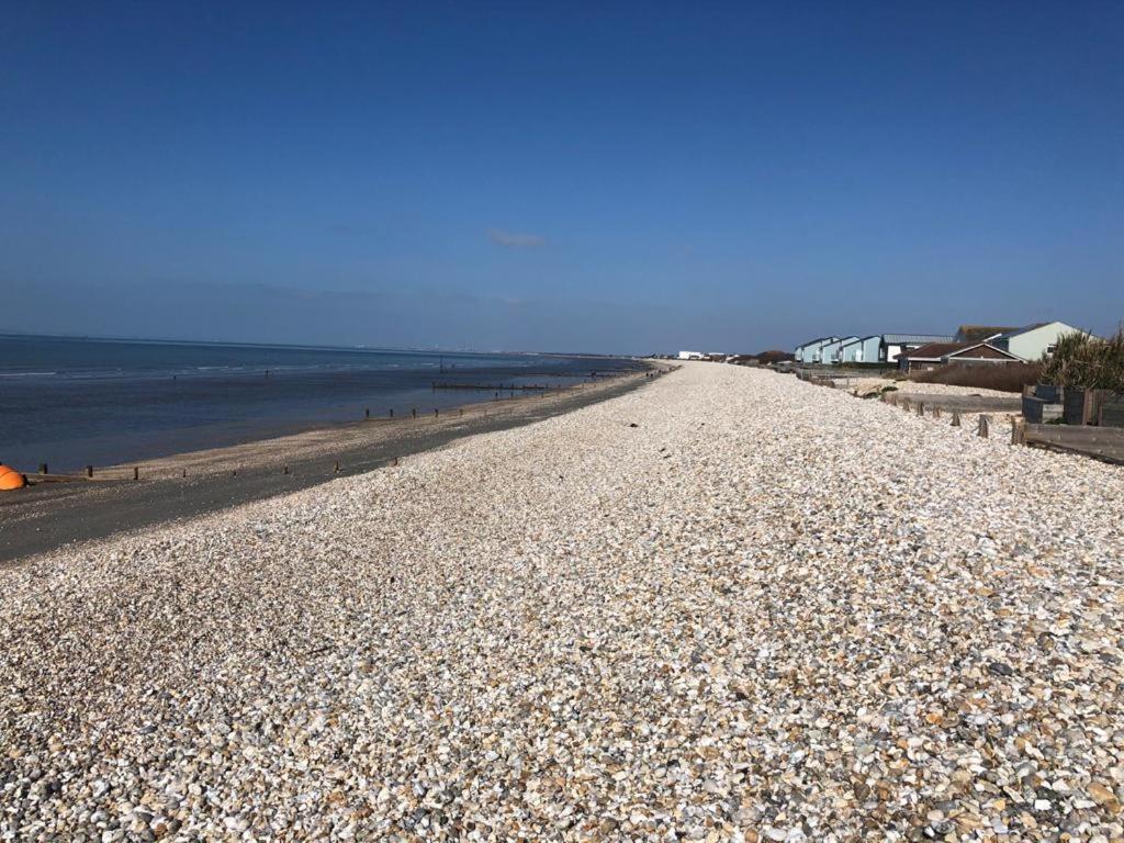 uma praia rochosa com o oceano ao fundo em Holiday house within 5 min walk from Bracklesham Bay beach em Earnley