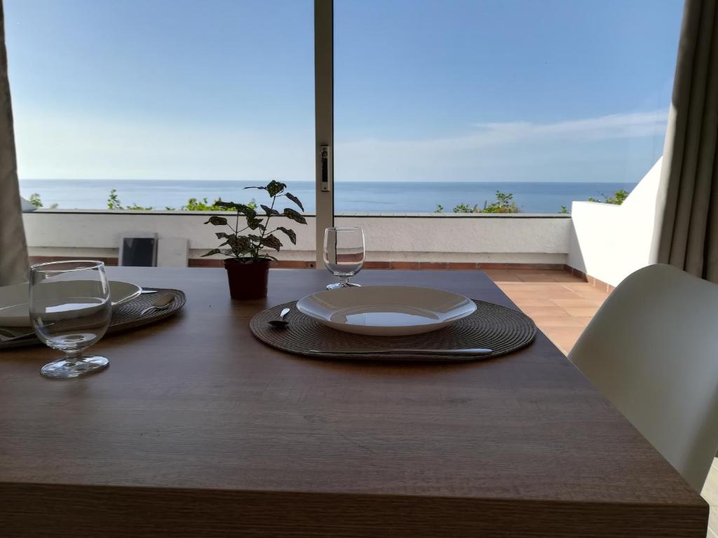 einen Tisch mit einem Teller und Weingläsern darauf in der Unterkunft Sunset La Palmita in La Victoria de Acentejo