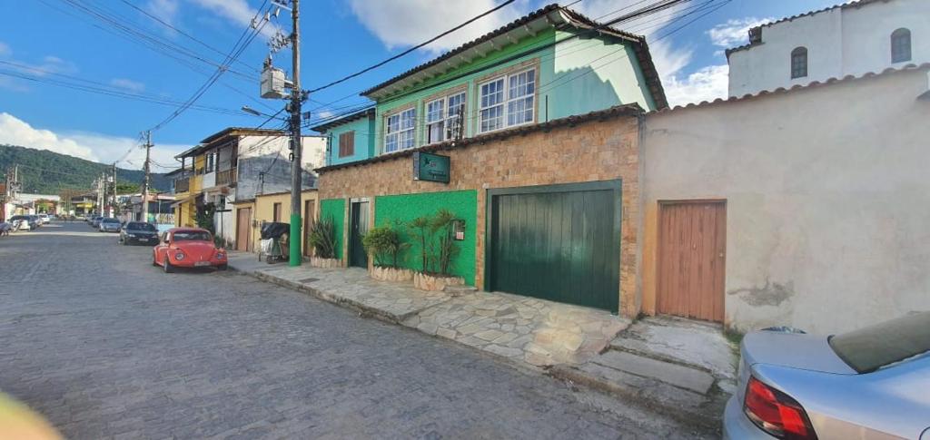 ein rotes Auto, das neben einem Gebäude auf einer Straße parkt in der Unterkunft Pousada Taquinha Paraty in Paraty