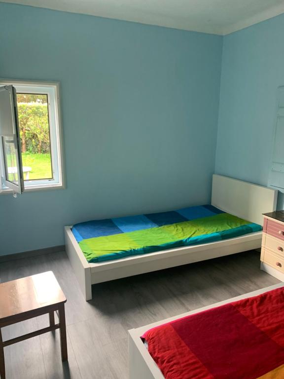 1 dormitorio con cama y ventana en Quinta do Norte - Biscoitos, en Angra do Heroísmo