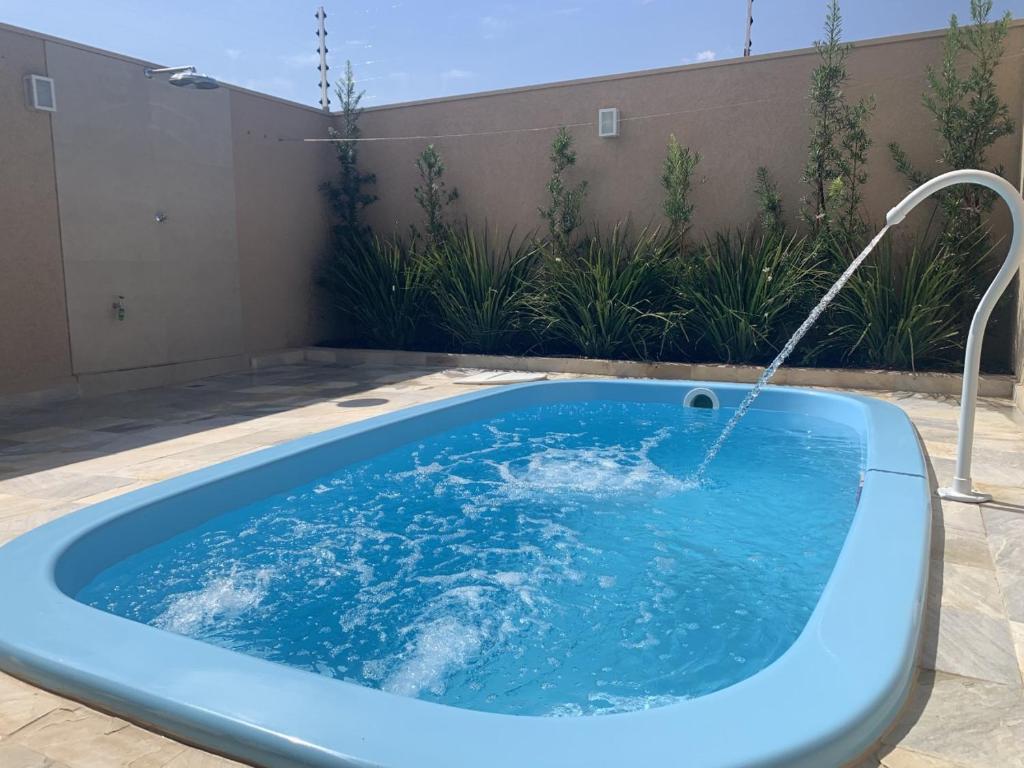 een blauwe hot tub met een fontein bij Tati's house Olímpia-casa para até 11 pessoas in Olímpia