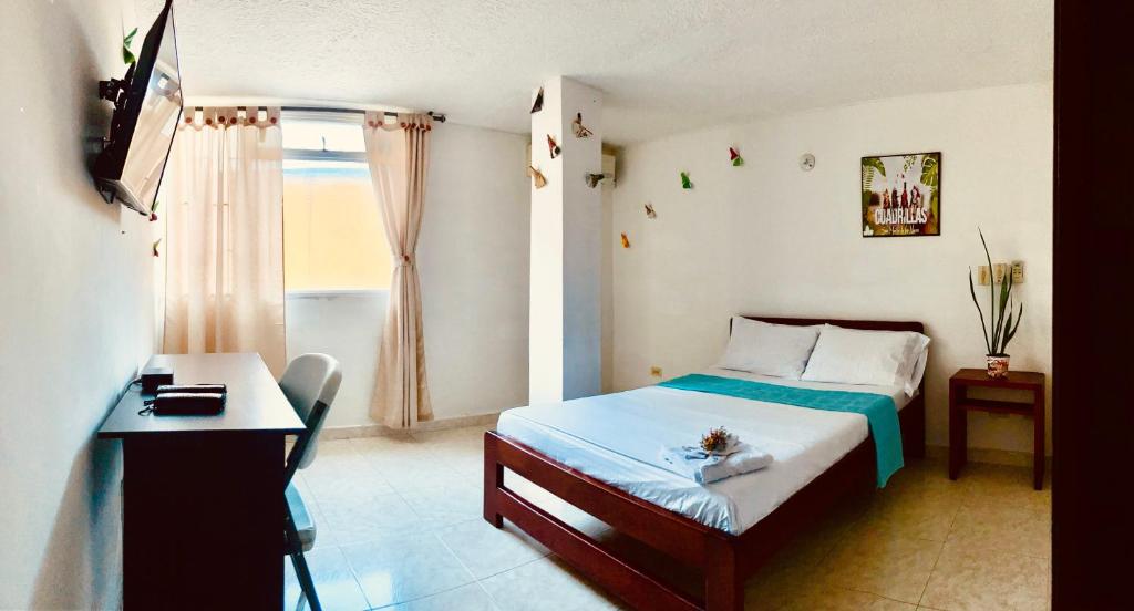 1 dormitorio con cama, escritorio y ventana en Refugio Llanero Hotel Boutique, en Villavicencio