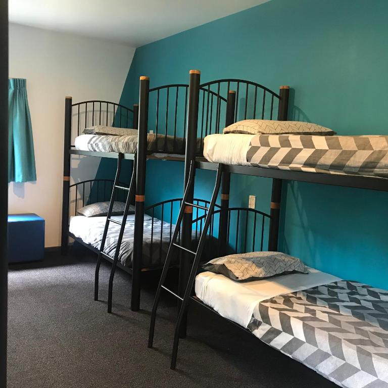 two bunk beds in a room with a blue wall at YHA Nelson in Nelson