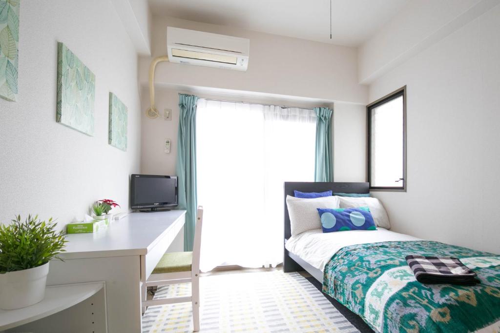 ein Schlafzimmer mit Bett, Schreibtisch und Fenster in der Unterkunft Escort Haruyoshi in Fukuoka
