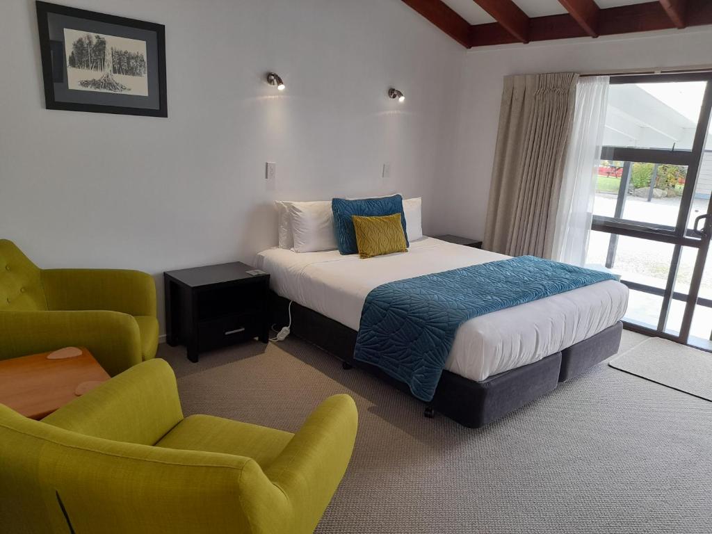 福克斯冰河的住宿－馬西森湖汽車旅館，一间卧室配有一张床、一张沙发和一把椅子