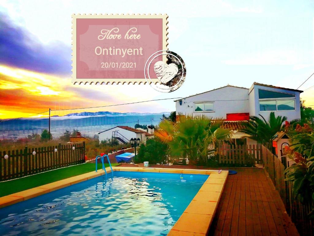 - une piscine en face d'une maison avec un coucher de soleil dans l'établissement La Rustika Ontinyent, à Ontinyent