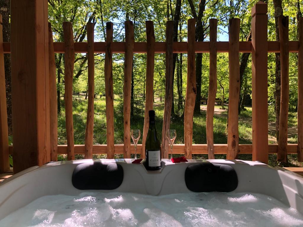 a bottle of wine sitting in a bath tub at Cabane Perchée Spa Dordogne La Ferme de Sirguet in Monsac