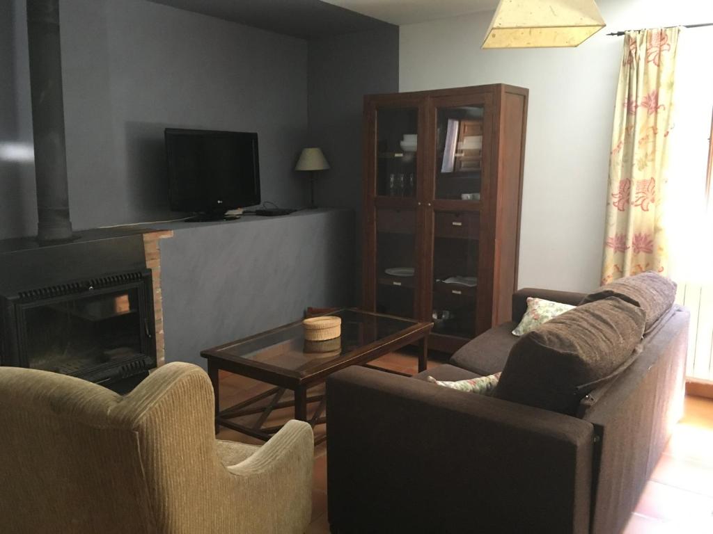 a living room with two chairs and a fireplace at Casa Clemente I in La Hiruela