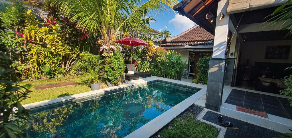 a house with a swimming pool in front of a house at Villa Esa Ubud in Ubud