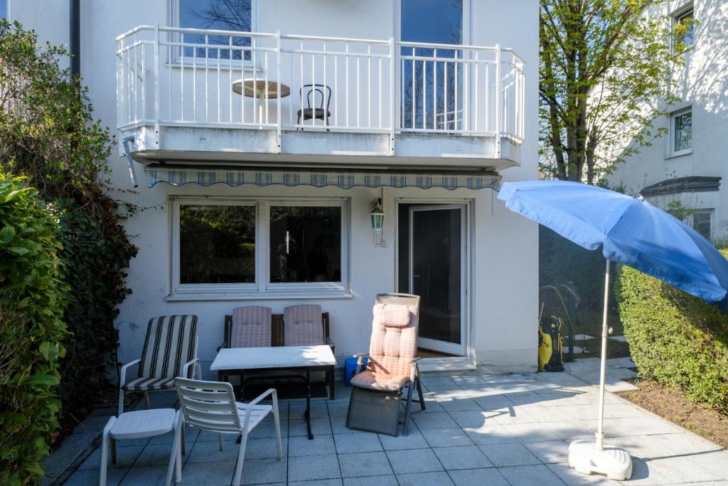 a patio with a table and chairs and an umbrella at Ganzes Haus möbliert Mü-Lerchenau in Munich