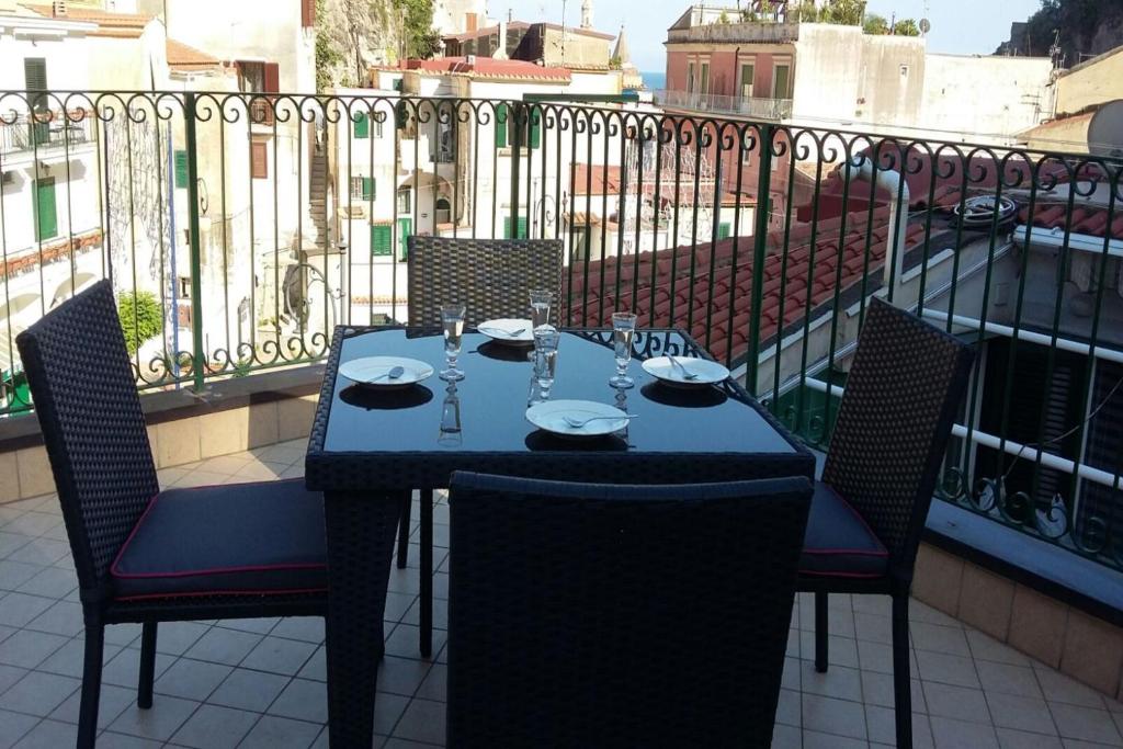 een tafel en stoelen op het balkon bij Cetara House 1 on Amalfi coast - Happy Rentals in Cetara