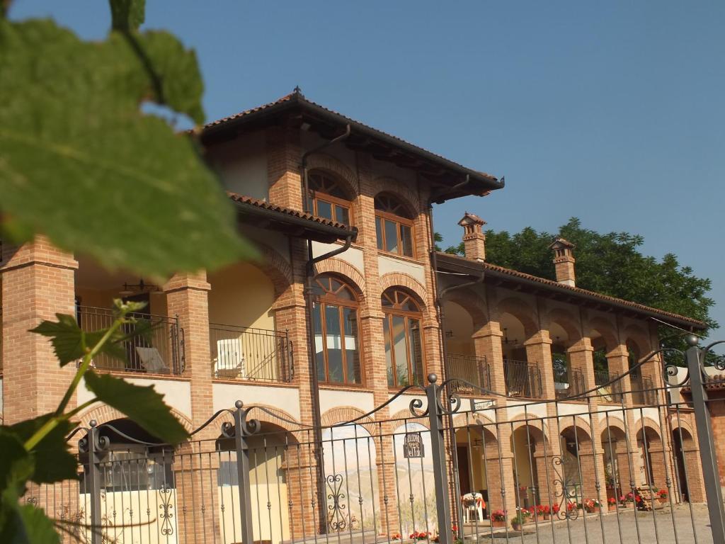 a large building with a fence in front of it at Enolocanda Del Tufo in Dogliani