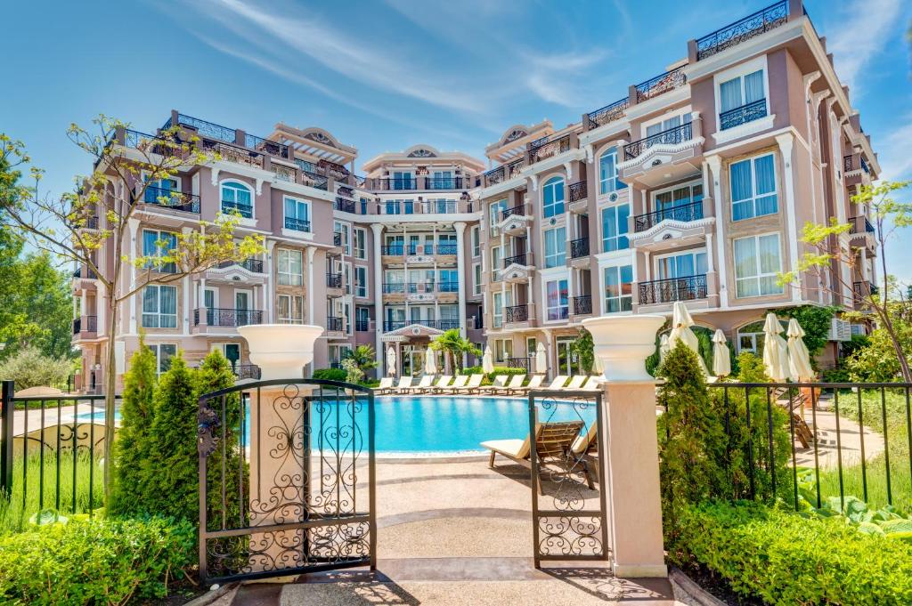an apartment building with a pool in front of it at Izida Palace Apartments in Sunny Beach
