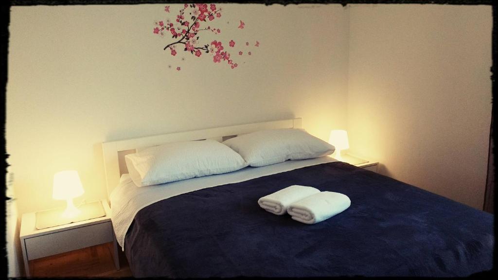 een slaapkamer met 2 handdoeken op een bed met 2 lampen bij Lu-Do Apartments in Trogir
