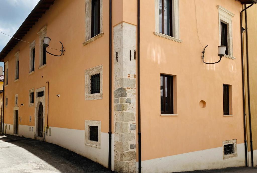 un edificio naranja con ventanas y un callejón en Il Sogno di Hypnos, en LʼAquila